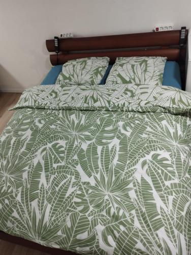 - un lit avec une couette et des oreillers verts et blancs dans l'établissement Studio centre ville Foix, à Foix