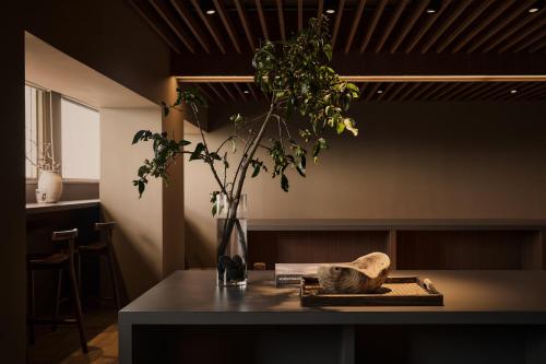 a table with a vase with a plant on it at Brown House Hotel - Taipei Main Station in Taipei