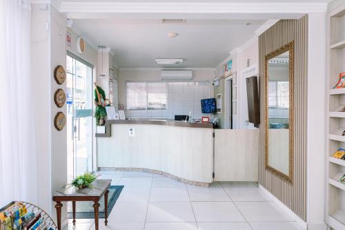 a living room with a counter and a mirror at Hotel Dinamarca in Balneário Camboriú