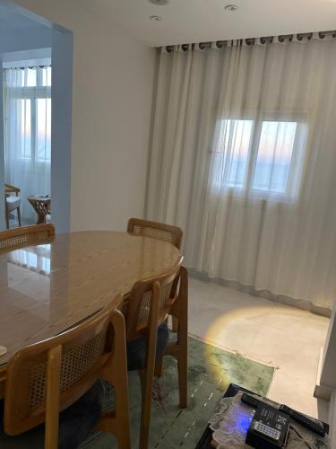 a dining room with a wooden table and chairs at Sea view in front of Hilton in Alexandria