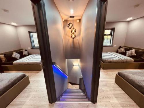 a room with two beds and a mirror at Urban Escape 4BedRoom House- With Free private Parking - Birmingham City in Birmingham