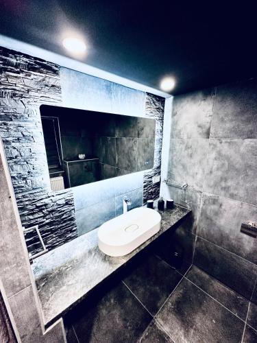 a bathroom with a white sink and a mirror at Trendy House 65 in Karácsond