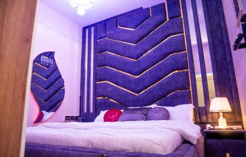a bedroom with a large bed with a large headboard at Kay&M Homes LLC in Abuja