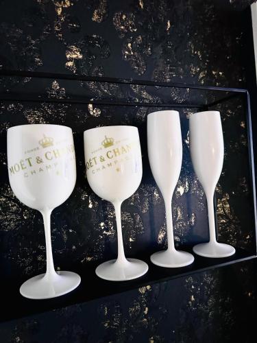 four wine glasses sitting on a black shelf at Trendy House 65 in Karácsond