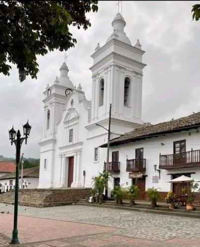 a large white building with a clock tower at Casa Rural Villa Milú in Guaduas