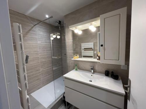 une salle de bain avec un lavabo et une douche en verre dans l'établissement Magnifique appartement pour 4 personnes face à la mer, à Saint-Gilles-Croix-de-Vie