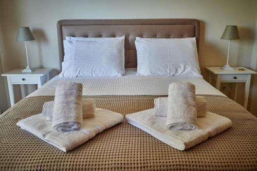 a bed with towels sitting on the foot of it at Luxury Apartment with Pool in Pallíni