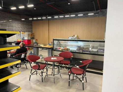 a man sitting at a table in a fast food restaurant at Stylish 2-Bedroom Apartment in Celia Compound, New Administrative Capital in Madīnat al Amal