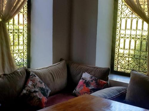 a living room with a couch and a table at KASBAH Jardin des délices Timalizen in Tamzerdirt