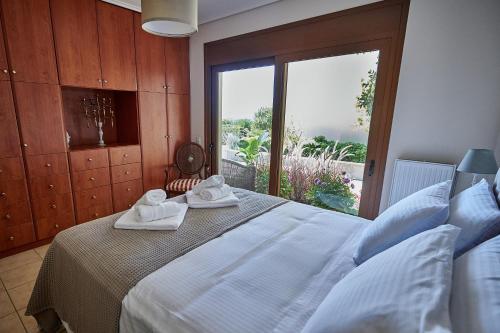 a bedroom with a large bed with towels on it at Luxury Apartment with Pool in Pallíni