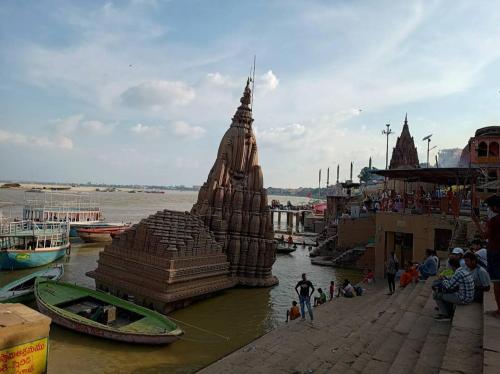a large stone structure in the water next to a river at Pushkarni Home Stay in Varanasi