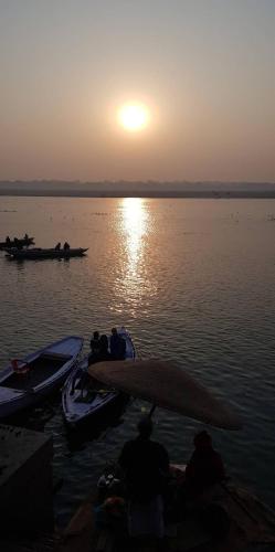 a group of people on boats in the water at sunset at Pushkarni Home Stay in Varanasi