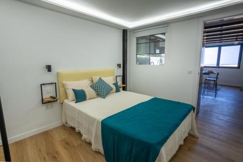 a bedroom with a bed with a blue blanket on it at La Brisa by Gran Canaria Homes in Playa del Hombre