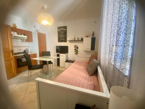 a room with a bed and a table and a kitchen at Jack's Place in Trbovlje