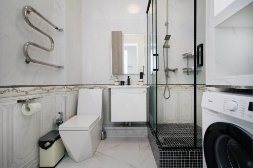 un baño con ducha, inodoro y lavabo en Central Avenue, en Almaty