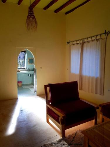 a living room with a couch and a window at KASBAH Jardin des délices Timalizen in Tamzerdirt