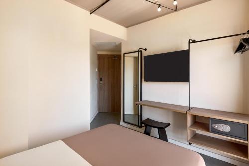 a small bedroom with a bed and a desk at tent Palmanova in Palmanova