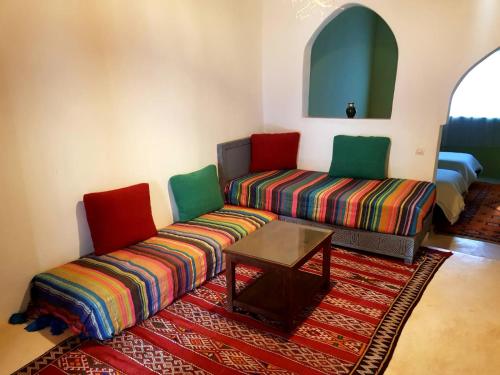 a living room with a couch and a table at KASBAH Jardin des délices Timalizen in Tamzerdirt