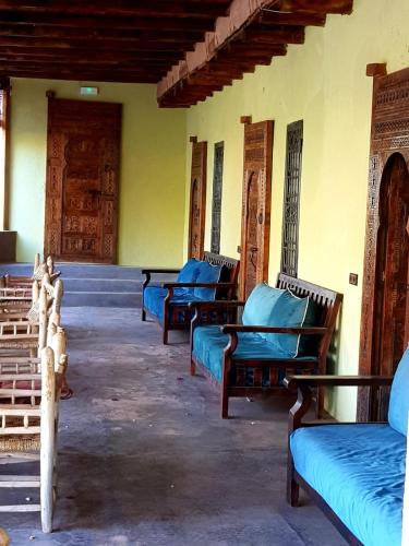 a group of beds in a room with doors at KASBAH Jardin des délices Timalizen in Tamzerdirt