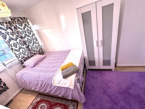 ロンドンにあるEXCELLENT DOUBLE ROOMS IN CHEAP RATE AROUND CENTRAL LONDONの小さなベッドルーム(紫の敷物付きのベッド付)