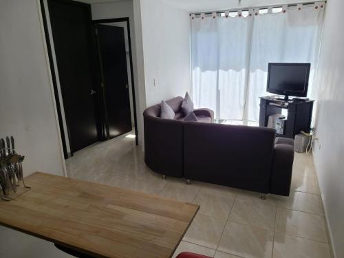 a living room with a couch and a television at Apartamento Armenia, como en casa! in Armenia