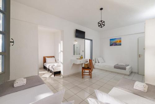 biały salon z łóżkiem i kanapą w obiekcie Kings Hersonissos Hotel w mieście Hersonissos