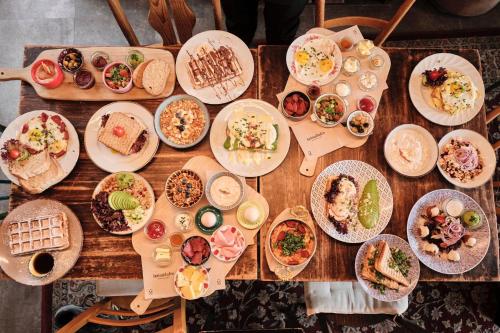 a wooden table with plates of food on it at Chérisy Hotel Konstanz - Self Check-in Only in Konstanz