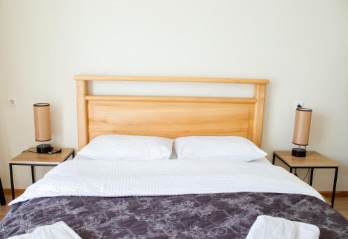a bedroom with a large bed with two night stands at Aronia Kazbegi in Stepantsminda