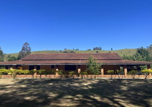 a building with a large yard in front of it at Recanto Sol Maior - Casa Girassol in Sapucaí-Mirim