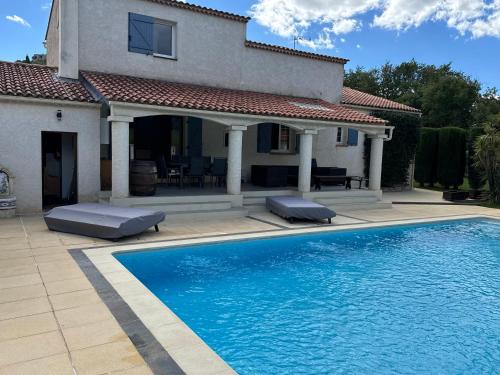 une maison avec une piscine devant une maison dans l'établissement Villa de Charme en Provence, à Forcalqueiret