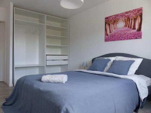 - une chambre dotée d'un lit bleu et d'une peinture murale dans l'établissement Appartement avec 2 chambres et parking privé, à Lille