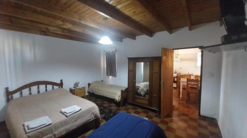 a bedroom with two beds and a mirror at Departamentos alvear in Esquel