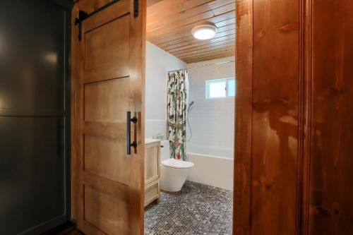 a bathroom with a toilet and a wooden door at 45 The Overlook in Wawona