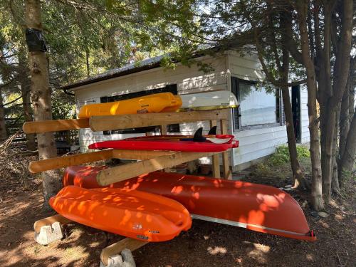 a group of kayaks sitting outside of a cabin at Entire waterfront cottage in carrying place in Carrying Place