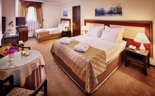 a hotel room with a large bed and a table at Güneş Hotel Merter in Istanbul