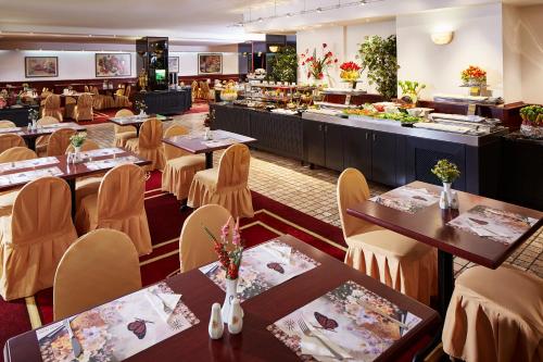 un restaurant avec des tables et des chaises et une cafétéria dans l'établissement Güneş Hotel Merter, à Istanbul