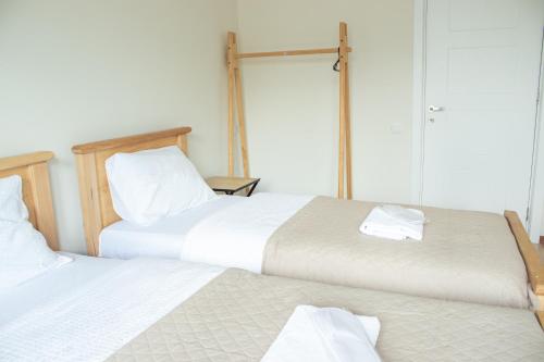 two beds sitting next to each other in a bedroom at Aronia Kazbegi in Stepantsminda