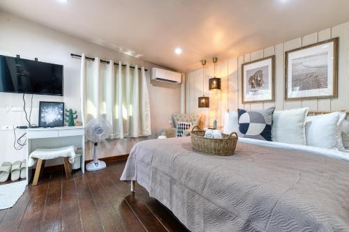 a bedroom with a large bed and a tv at Jasmine Garden Bungalow in Lamai