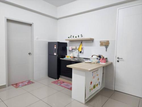 a kitchen with a black refrigerator and a counter at Cozy FamiLee Homestay in Simpang Ampat