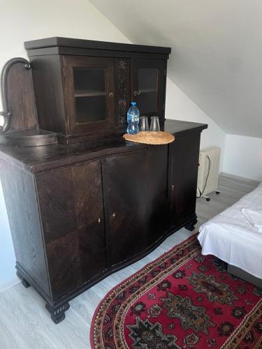 a wooden cabinet with a bottle of water on top at Myśliwskie Smaki U Tadka in Czeczewo