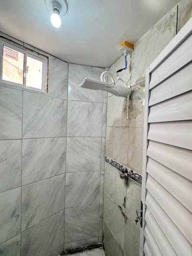 a shower with a glass door in a bathroom at Ap próximo ao Arco com garagem e ar in Sobral