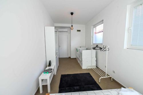 a white room with a bed and a desk at Paun Apartmani in Smederevo
