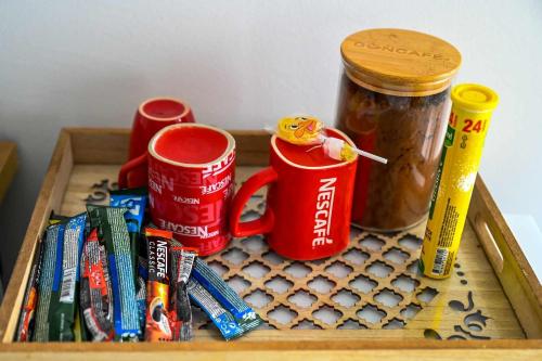 a wooden tray with two red cups and some food at Paun Apartmani in Smederevo
