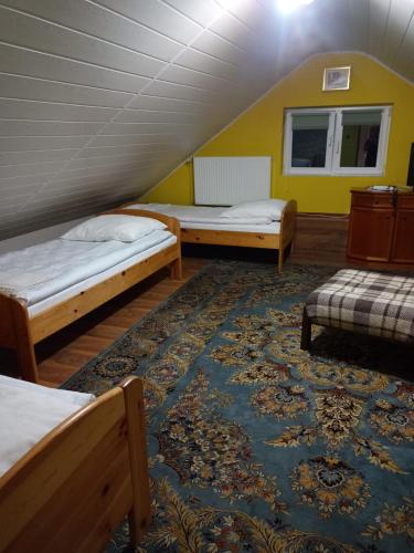 a room with two beds and a rug at Lorsby- wędkarska oaza in Mrągowo