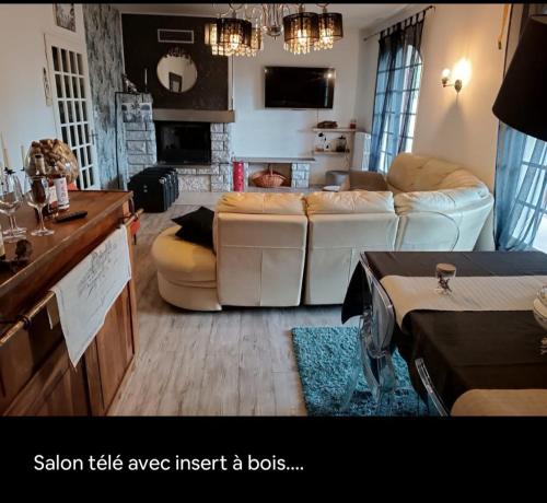 a living room with a couch and a table at Villa Provençale avec Spa Piscine Privée in Ris