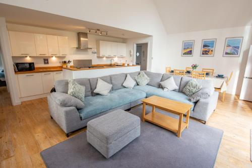 una sala de estar con un sofá y una mesa en Tarka Summerhouse, en Woolacombe