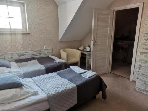 a bedroom with two beds and a table and a window at Jaś i Małgosia in Poraj