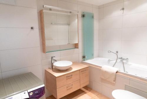 a bathroom with a sink and a toilet and a tub at Résidence Grenon in Crans-Montana