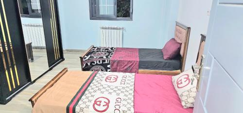 two beds sitting next to each other in a room at appartement luxueux in Alger