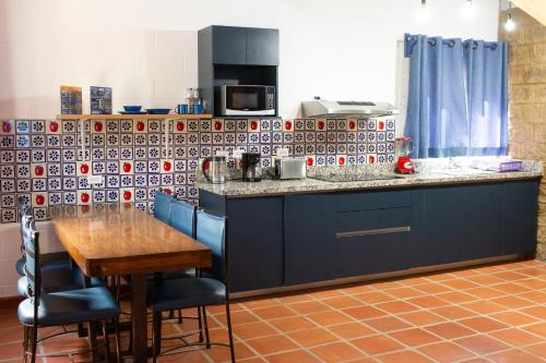 a kitchen with a counter and a table with chairs at Cabañas Bungalos las Alazanas in San Antonio de las Alzanas